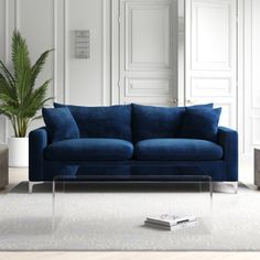 a living room with white walls and blue couch in the center, coffee table on the far side