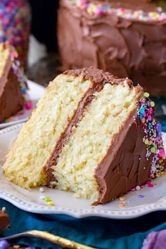 a slice of cake with chocolate frosting and sprinkles on a plate