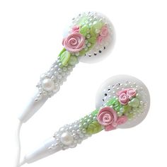 two hairbrushes with flowers and pearls on the heads, one is pink and green