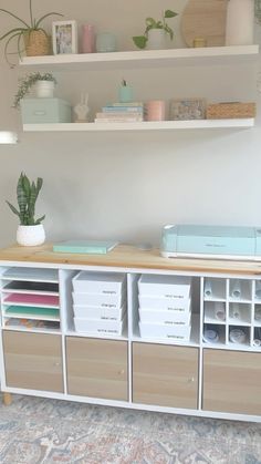 a white shelf filled with lots of crafting supplies next to a wall mounted bookcase