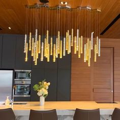 a kitchen with a large chandelier hanging from the ceiling and chairs in front of it