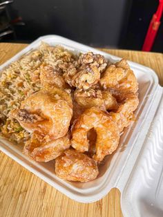 a plastic container filled with fried food on top of a wooden table