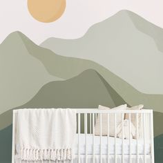 a baby crib in front of a wall with mountains painted on it and a sunset