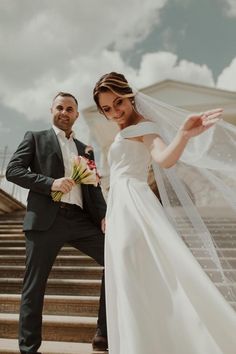 a bride and groom posing on the steps