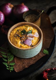 a bowl filled with hummus and onions on top of a plate