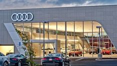 an audi dealership with cars parked in front