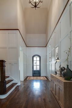 an empty hallway with wooden floors and white walls