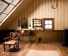 a room with a chair, desk and window in the wall next to an attic