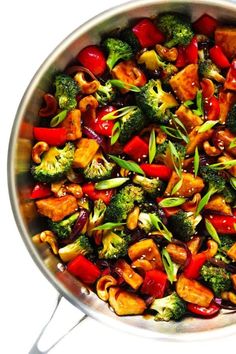 a pan filled with stir fry vegetables on top of a stove