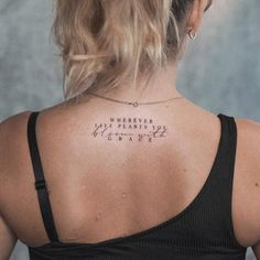 the back of a woman's neck with words written on her upper and lower back