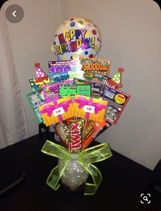 a vase filled with candy and balloons on top of a table