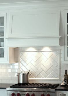 a stove top oven sitting inside of a kitchen next to white cabinets and counter tops