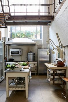 an industrial style kitchen with stainless steel appliances and counter tops is shown in this image