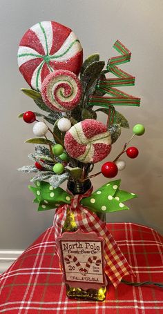 a vase filled with candy canes and candies on top of a red table cloth