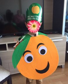 a person in a costume made to look like a pumpkin with a flower on top