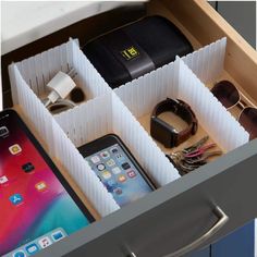 an iphone and other electronics are in a drawer next to each other on the table