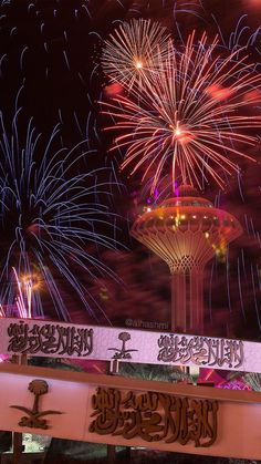 fireworks are lit up in the night sky above a building with a clock on it