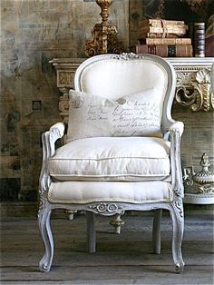 a white chair sitting in front of a book shelf