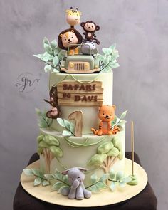 a three tiered cake with animals on top