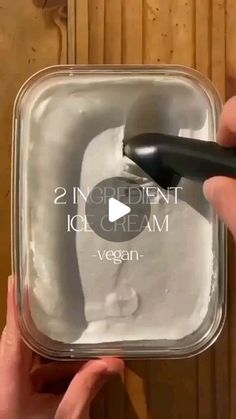 a person is using an ice cream scooper to mix ingredients in a container with the words, 2 ingredient ice cream