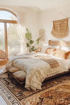 a large bed sitting in a bedroom on top of a rug next to a window