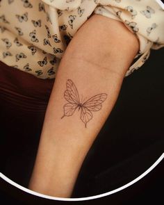 a woman's arm with a butterfly tattoo on the left side of her arm