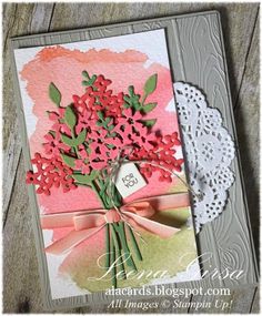 a close up of a greeting card with flowers on the front and pink ribbon around it