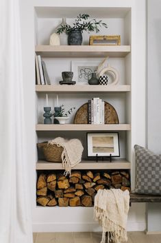 a book shelf filled with books next to a chair and other items on top of it