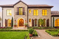 a large house with many windows and plants in the front yard