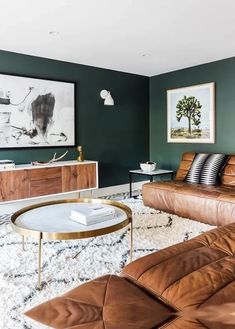 a living room with green walls and leather furniture