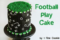 a football cake with green frosting and white icing on a black plate that says football play cake