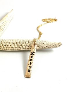 a gold necklace with an inscription written on it and a starfish in the background