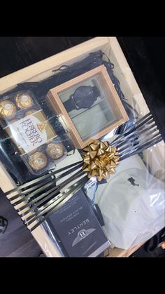 a gift box with chocolates, wine and other items in it on top of a table