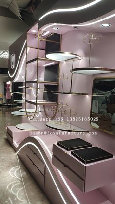 the interior of a store with pink and gold furniture, mirrors, lights and lighting fixtures