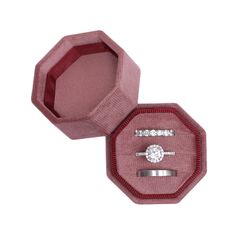 an open pink velvet ring box with a diamond set in the top and bottom, on a white background