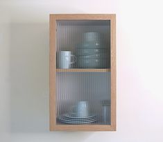 a wooden shelf filled with dishes and cups