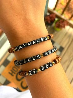 a person wearing three bracelets with words on them