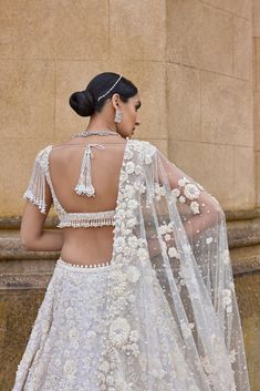 This lehenga set features three-dimensional embroidery in a bold floral pattern in thread, pearl, sequin and beads. The blouse has a plunging neckline and shows exaggerated pearl tassels. It is paired with a matching four sided embroidered dupatta. It is paired with an optional embroidered organza cape with a trail at the back.From Seema Gujral's A Royal Affair collection. DELIVERY TIMEPlease allow 8-12 weeks for your outfit to arrive. FABRIC DETAILSNet Professional cleaning only. Indian Wedding Outfits Guest, Floral Bridal Lehenga, Hand Embroidered Skirt, Mauve Skirt, Organza Cape, Pearl Tassels, Saffron Spice, Seema Gujral, Dimensional Embroidery