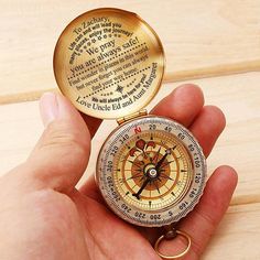 a person holding a compass in their hand with the words written on it and an open keychain