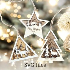 three wooden christmas ornaments hanging from a tree with lights in the background and text saying merry christmas svg files