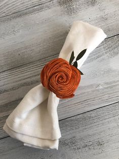 an orange flower on top of a white napkin