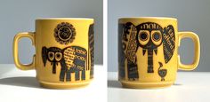 two mugs with designs on them sitting side by side, one is yellow and the other is black