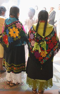 two women in colorful clothing standing next to each other