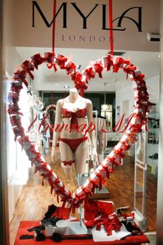 a display in a store window with red and white hearts hanging from it's sides