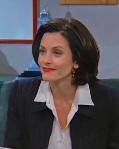 a woman in a suit and red lipstick on the set of tv show good morning america