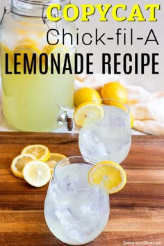 two glasses filled with lemonade sitting on top of a wooden table