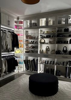 a closet with lots of shoes and handbags on the shelves in front of it