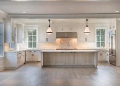 an empty kitchen with white cabinets and wood floors is seen in this image from the inside