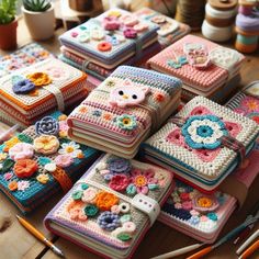 there are many crocheted notebooks that have flowers on them and animals on them