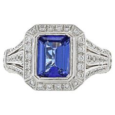 This bold art deco design ring, crafted in enduring 18KT white gold, embodies timeless elegance. The focal point is a striking 1.80CT emerald-cut tanzanite, accentuated by 0.48CT-TW of G color and VS1-VS2 clarity round-cut diamonds. The ring's combination of bold design, vibrant tanzanite, and sparkling diamonds create a piece that seamlessly merges sophistication with enduring style. It stands as a testament to both artistry and refinement in jewelry. Size 6 US. Weight 7.7 gm. Tanzanite And Diamond Ring, Tanzanite Diamond Ring, Art Deco Diamond Rings, Tanzanite Diamond, Bold Art, Gold Art Deco, Estilo Art Deco, Deco Jewelry, Art Deco Diamond